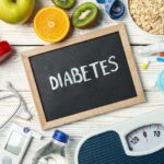 Word Diabetes and diabetic accessories on wooden background